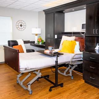 A well-designed hospital room featuring a comfortable patient bed and modern furnishings.