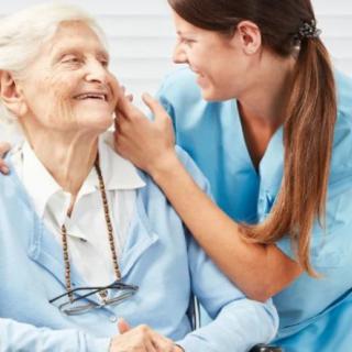 A caregiver interacting warmly with an elderly woman, highlighting compassionate elderly care.