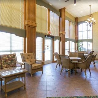 A spacious lobby area with comfortable seating, large windows, and a chandelier.