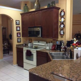 A cozy kitchen with dark wooden cabinets, white appliances, and decorative elements.