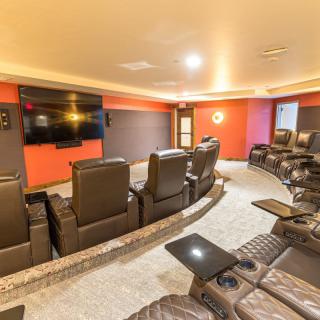 A cozy home theater with comfortable leather seating and a large screen for entertainment.