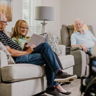 A group of seniors relaxing and socializing in a living room setting.