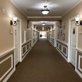 A well-lit hallway with multiple doors and traditional decor.