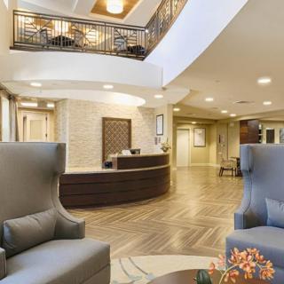 A modern hotel lobby with comfortable seating and a central reception desk.