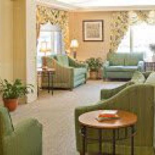 A cozy living room with green sofas and elegant decor.
