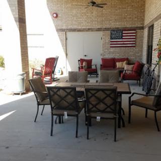 A cozy outdoor patio area equipped with a dining table and comfortable seating, adorned with an American flag.