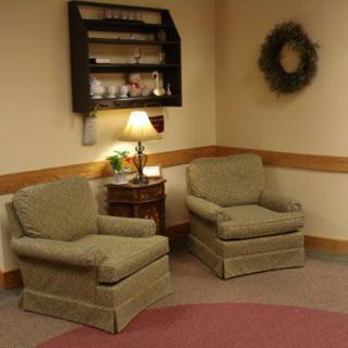 A cozy corner with two upholstered chairs, a lamp, and decorative accents.