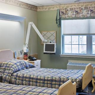 A hospital room with two beds and medical equipment.