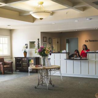 A welcoming reception area with a desk and flowers on display.