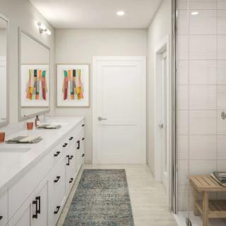A modern bathroom featuring double sinks, a large mirror, and a walk-in shower.