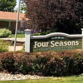 A sign for the Four Seasons Countryside Retreat amidst lush greenery.