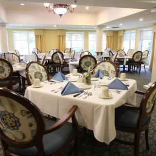 An elegantly set dining room with neatly arranged tables and chairs.