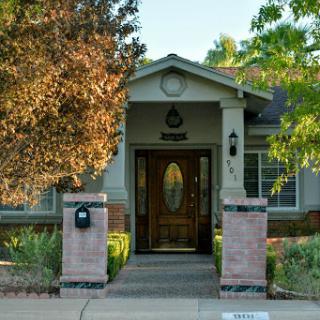 A welcoming entrance to a charming home surrounded by lush greenery.