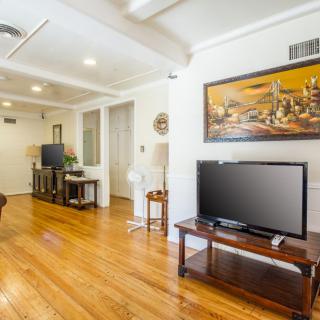 A contemporary living room with hardwood floors, a TV, and modern decor.