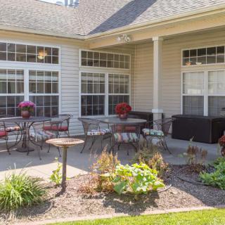 A cozy patio area with outdoor seating, surrounded by a well-maintained garden.