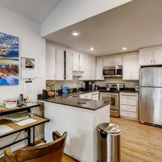 Modern kitchen with stainless steel appliances and a small desk area.