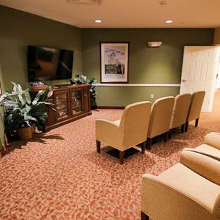 A cozy home theater room with comfortable seating and a large television.