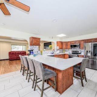 A spacious and modern kitchen featuring an island with bar stools, equipped with stainless steel appliances and elegant cabinetry.