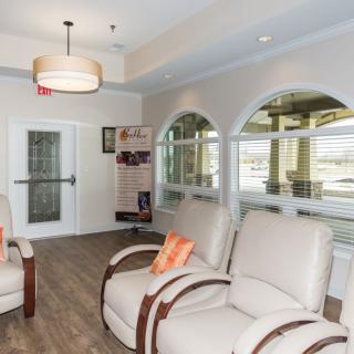 A comfortable waiting room with plush chairs and large windows.