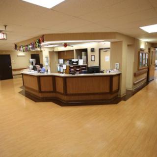 A hospital reception area featuring a central desk and surrounding hallway.