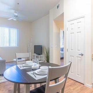 A cozy apartment interior featuring a set dining table and a comfortable living room area.