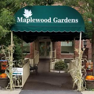 The welcoming entrance of Maplewood Gardens, adorned with autumn decorations.