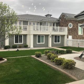 A view of a modern two-story house with a well-maintained yard and balconies.