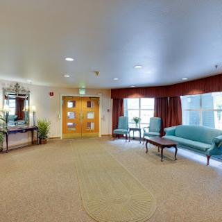 A spacious and welcoming lounge area featuring comfortable seating and warm lighting.