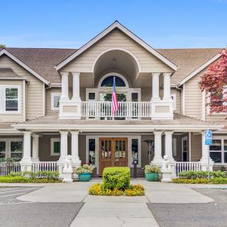 A charming two-story building with a grand entrance and well-maintained landscaping.