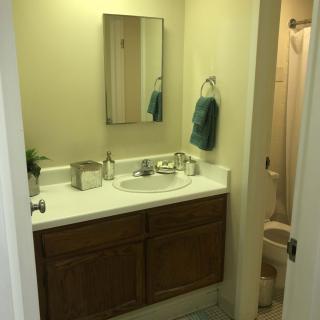 A small bathroom with a sink, mirror, and towel hanging on the wall.