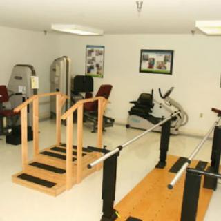 A physical therapy room equipped with rehabilitation and exercise equipment.