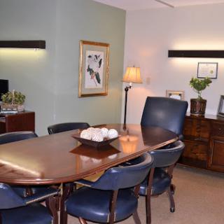 A modern conference room featuring a wooden table, blue chairs, and tasteful decor.