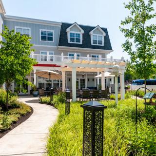 A beautifully landscaped garden path leading to a charming building with outdoor seating.