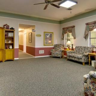 A cozy living room with floral-patterned sofas and warm lighting.