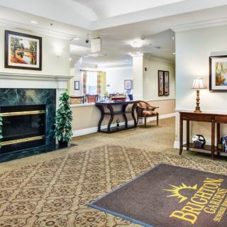 A welcoming lobby area featuring a fireplace, elegant furniture, and artwork on the walls.