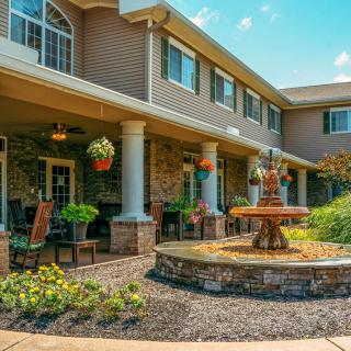 A beautiful building exterior with a landscaped garden and fountain area.