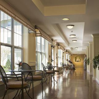 A well-lit hallway with seating areas and large windows.