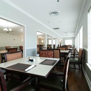 An empty restaurant dining area with neatly arranged tables and chairs.