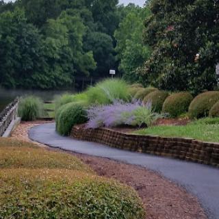 A serene pathway winding through a beautifully landscaped park by the water.