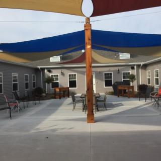 A courtyard with various colored shade sails and outdoor seating arrangements.