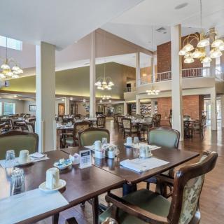 A spacious dining area with neatly arranged tables and elegant chandeliers.