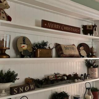 A festive shelf display with Christmas decorations and rustic holiday accents.