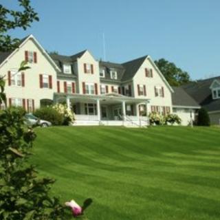 A large house with a well-maintained lawn under a clear blue sky.