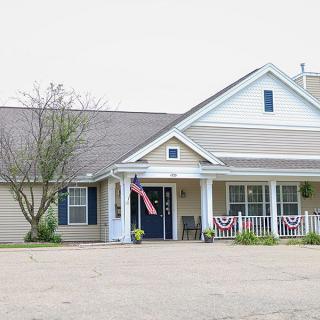 A residential building with a porch and patriotic decorations.
