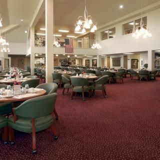 Spacious restaurant interior with elegant chandeliers and neatly arranged tables.