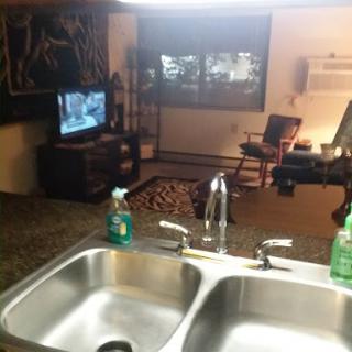 A cozy home interior featuring a kitchen sink and a living area with a TV.