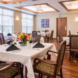 A well-decorated dining room with elegantly set tables and chairs.