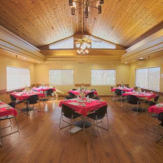 A cozy dining area with red tablecloths and a wooden ceiling.
