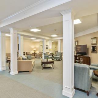 A spacious and cozy lounge area with comfortable seating and classic columns.
