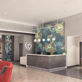 A stylish hotel lobby featuring a modern reception desk and vibrant wall art.